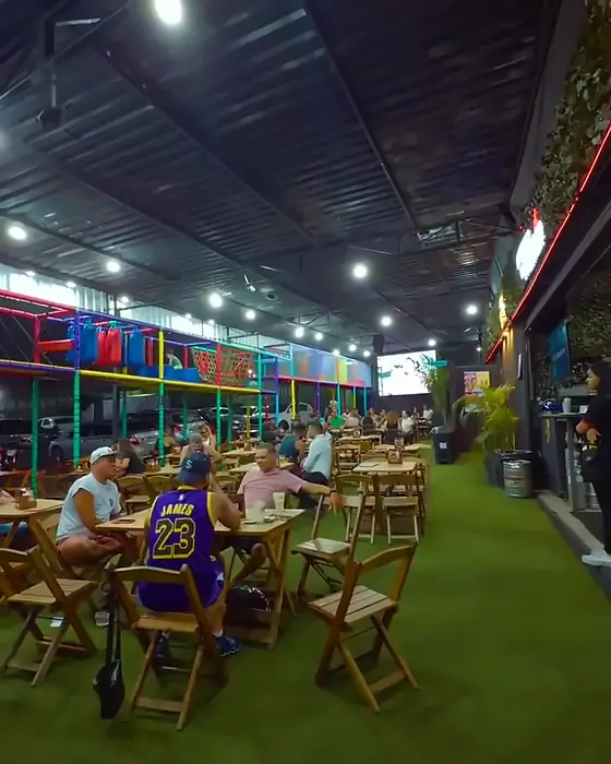 O espaço coberto: Grama, coqueiros e mesa de madeira